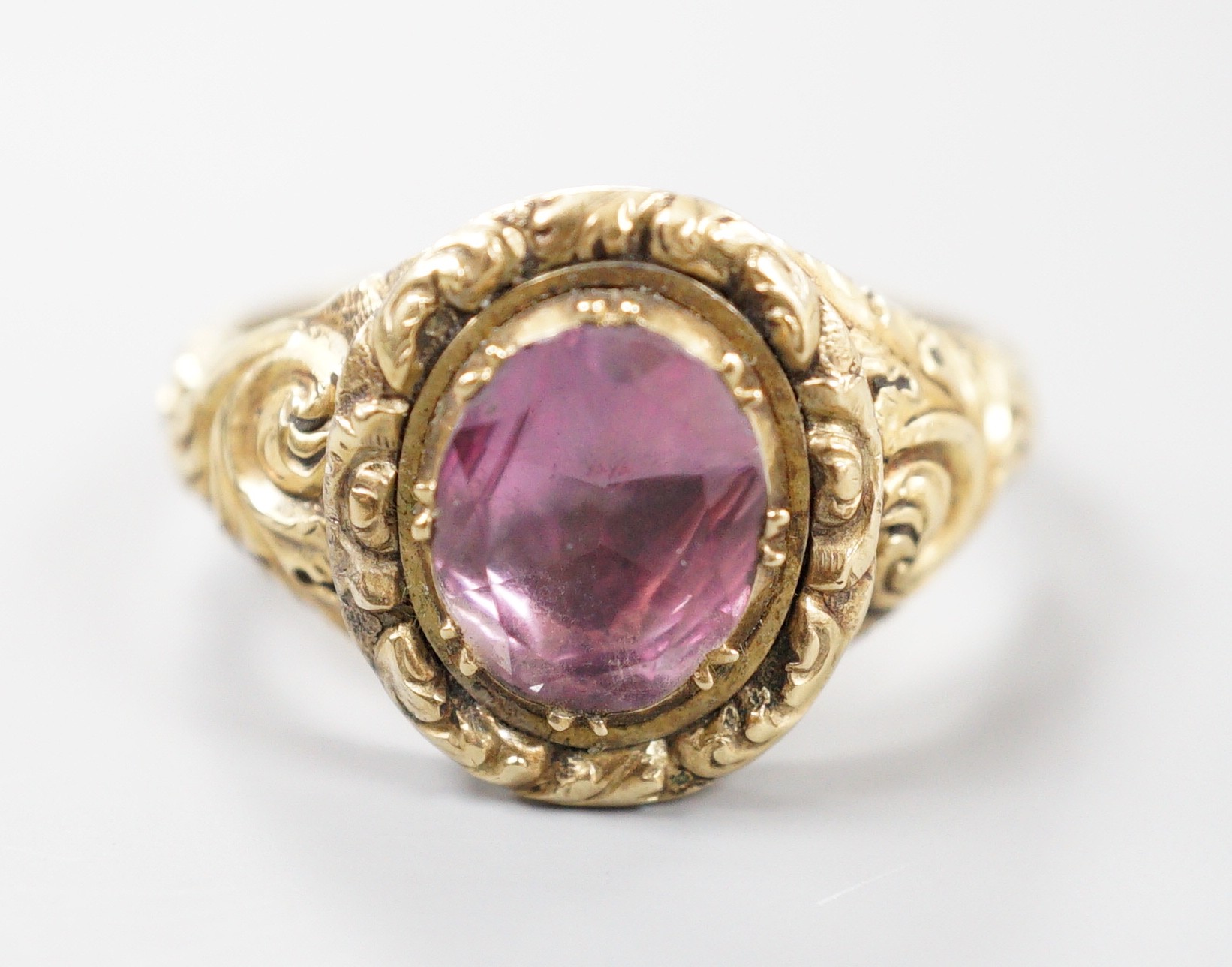 A Georgian yellow metal and foil backed quartz set oval ring, with carved setting and shoulders, size S/T, gross weight 6.4 grams.